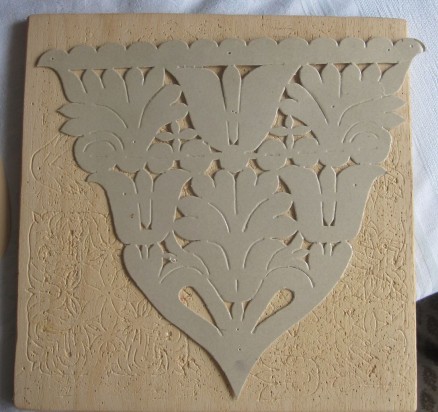 paperboard template of a chest stomacher on a pad board