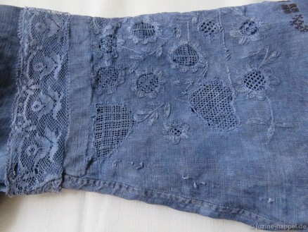 Sleeve cuff of a traditional dyed-to-blue Schwalm bodice decorated with bobbin lace, whitework, and Cross stitch initials.