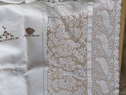 Bed covering with two different crowns with initials, filet, and a machine-made lace.
