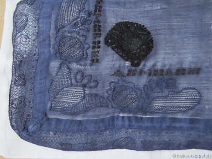 Very old decorative handkerchief dyed to blue. It is decorated with a Schwalm crown and initials worked with Cross stitches, whitework motifs, and a band with Dresden lace at two edges (and a small bobbin lace band at the remaining two edges – not shown in this picture).